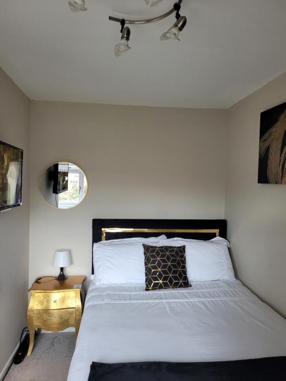 a bedroom with a white bed with a black headboard at NB's Cozy Nook in Shevington