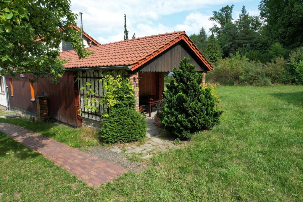 uma pequena casa num quintal com dois arbustos em Ferienwohnung Rother 