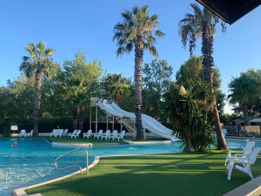 una piscina con un tobogán en un complejo en Mobil-home bord de mer, en Vendres