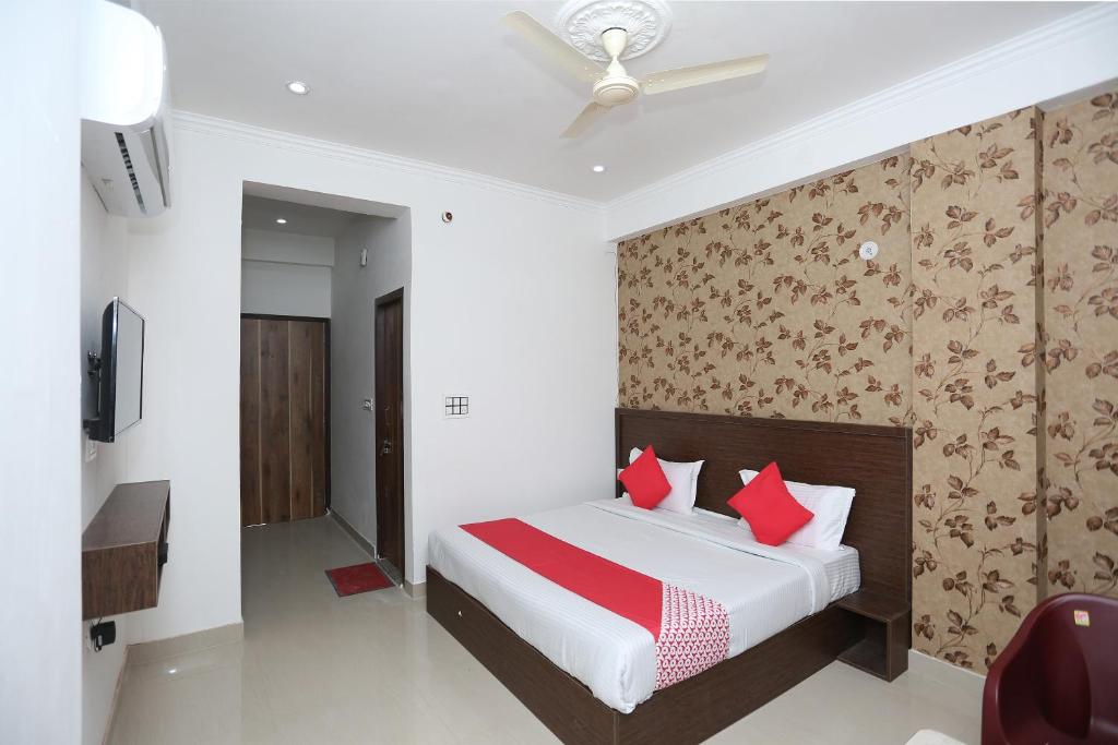 a bedroom with a bed with red pillows at OYO Hotel Vandana in Alwar