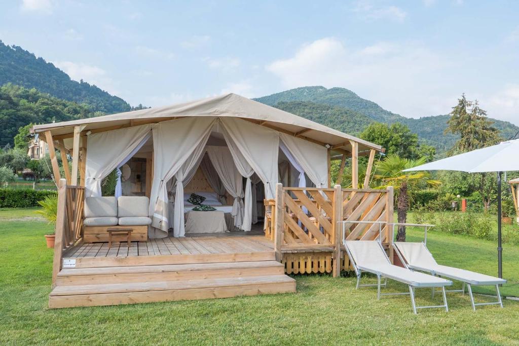 a luxury tent with two chairs and an umbrella at Luxury Lodge in Bellagio