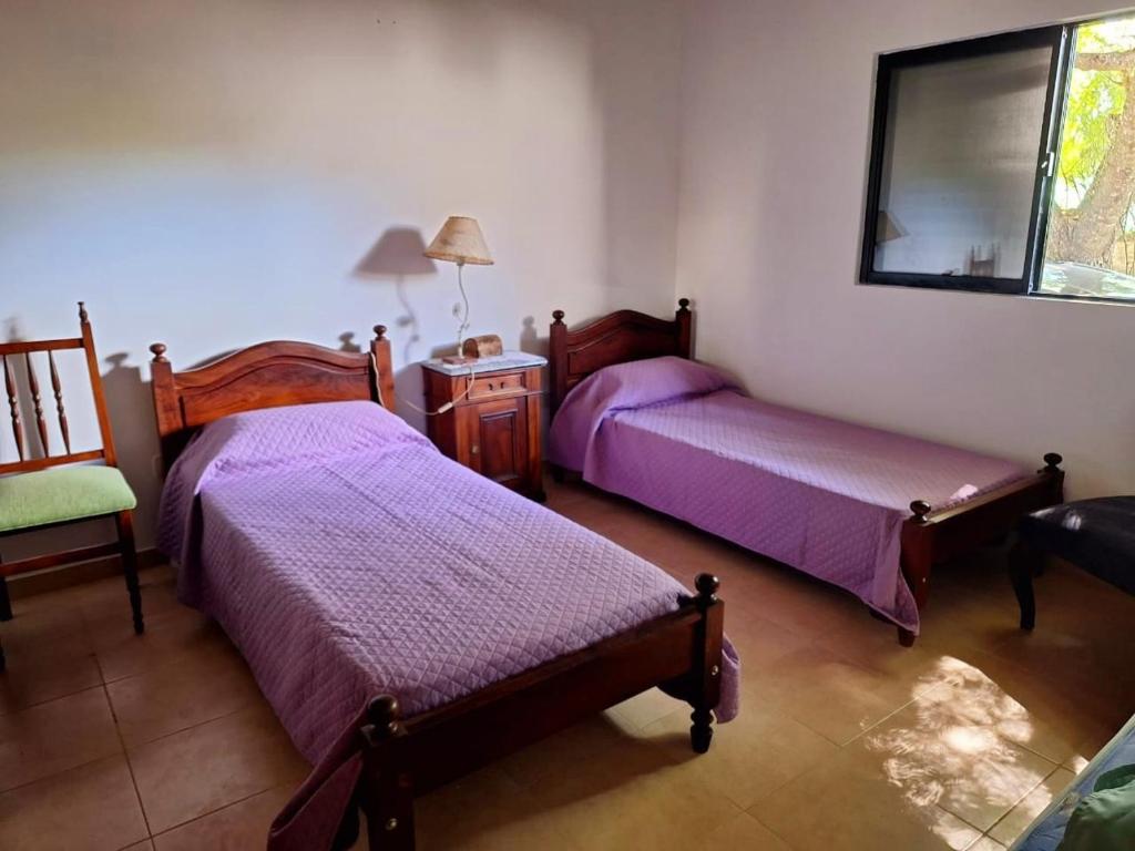 1 dormitorio con 2 camas, mesa y espejo en Cabaña La Encarnación en La Paz