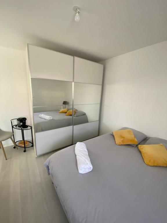 1 dormitorio con 1 cama blanca grande y espejo en Maison vue mer st anne du Portzic en Brest