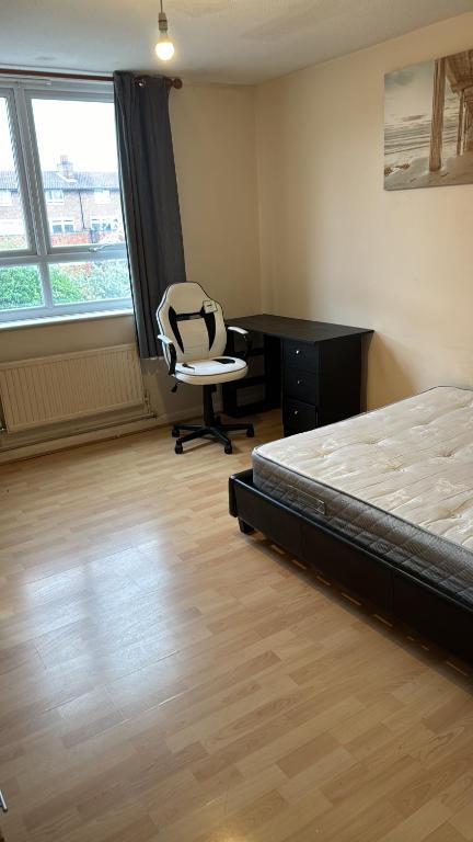 a bedroom with a bed and a desk and a chair at Eynsford down in London