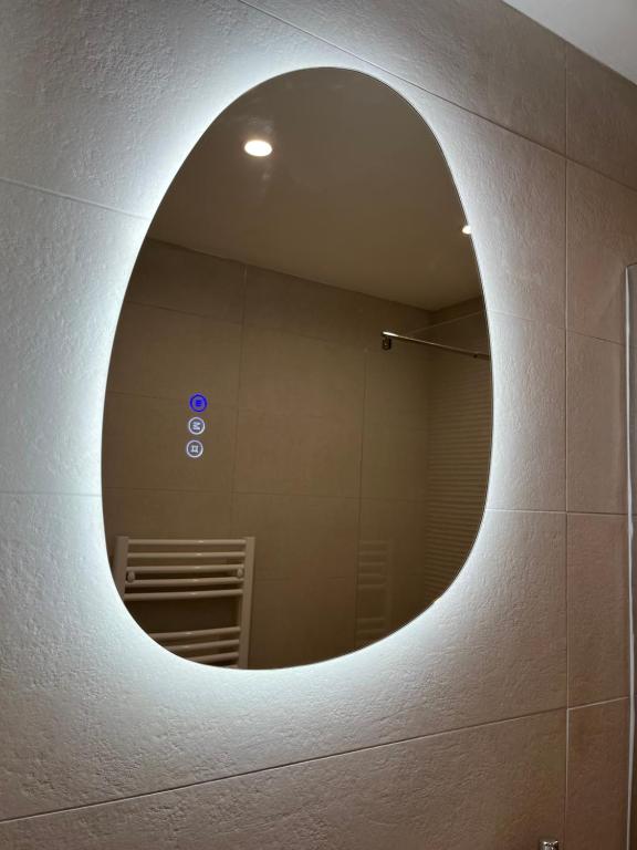 - un miroir circulaire sur un mur dans la salle de bains dans l'établissement Appartement Balaruc les bains, à Balaruc-les-Bains