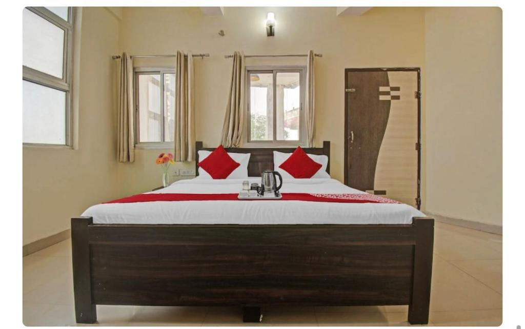 a bedroom with a large bed with red pillows at AK VILAS - BEST BUDGETED HOTEL IN JAIPUR in Jaipur