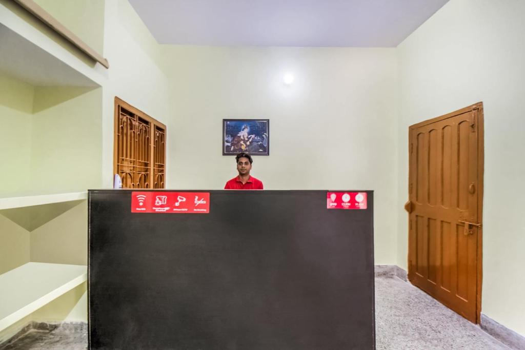 a man standing behind a counter in a room at OYO Flagship Adam's Bridge International Hotel in Patna