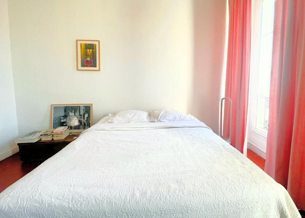 a bedroom with a large white bed and a window at La Pivoine in Marseille