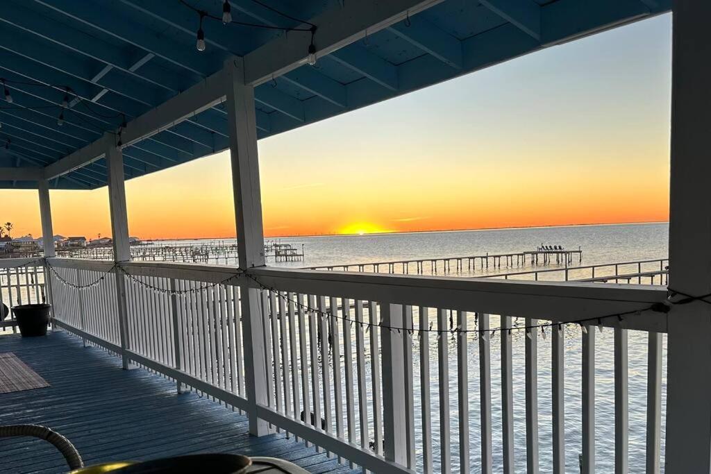 a view of the beach at sunset from a balcony at Bay Haven on Copano- 4 bdrm w/ 200+ft Fishing Pier in Rockport