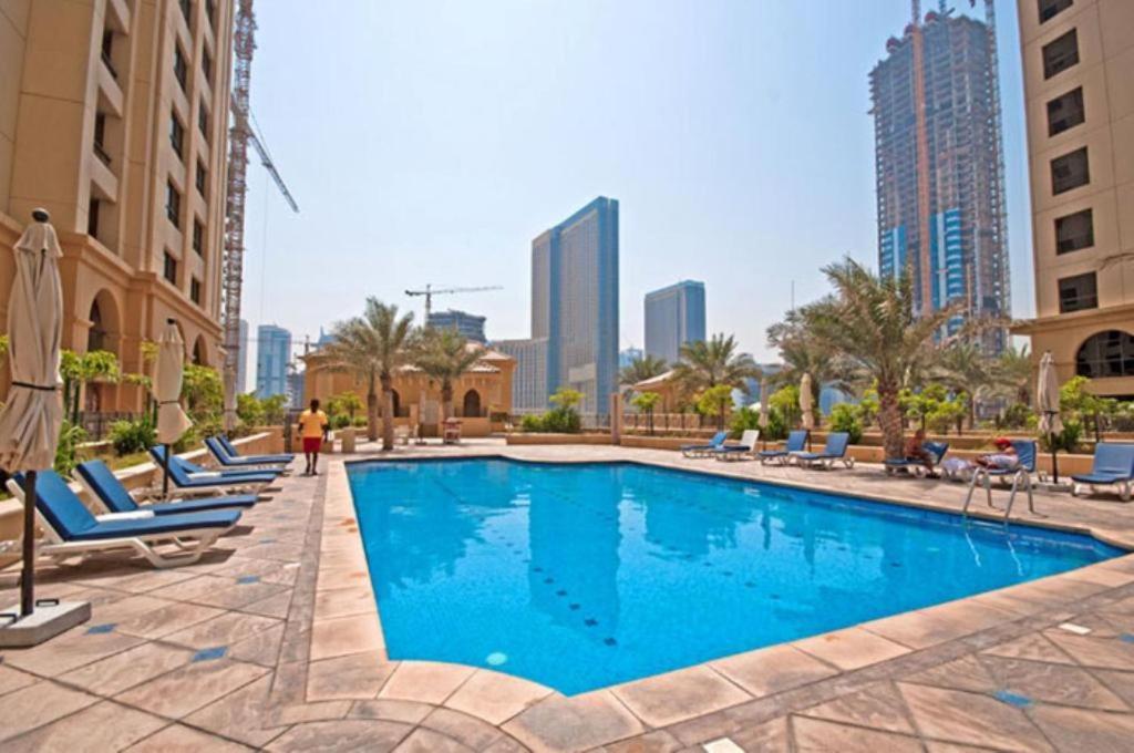 una piscina con tumbonas y edificios en Urban Heaven, Luxury Hostel - JBR - Walk To Beach, Metro Station, en Dubái