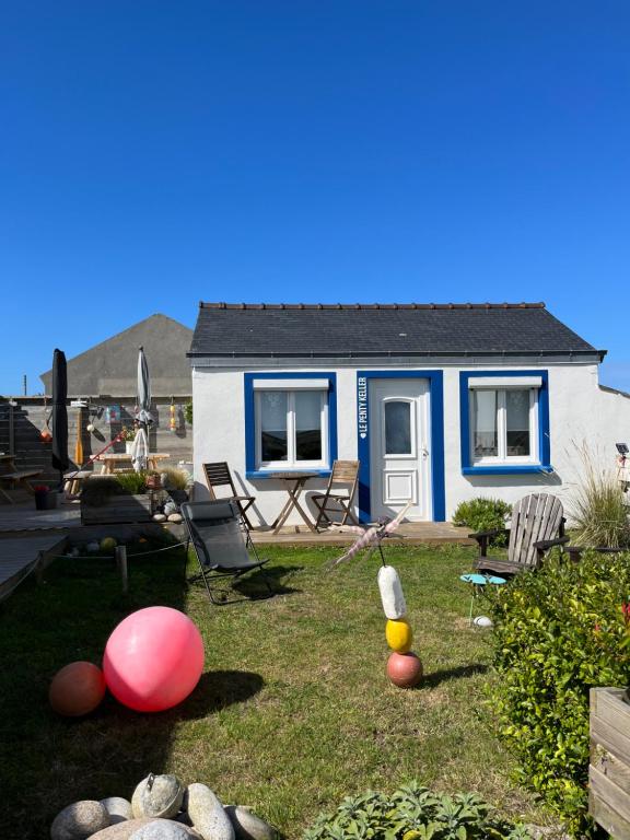una casa azul y blanca con pelotas en el patio en Penty de Mézareun en Lampaul