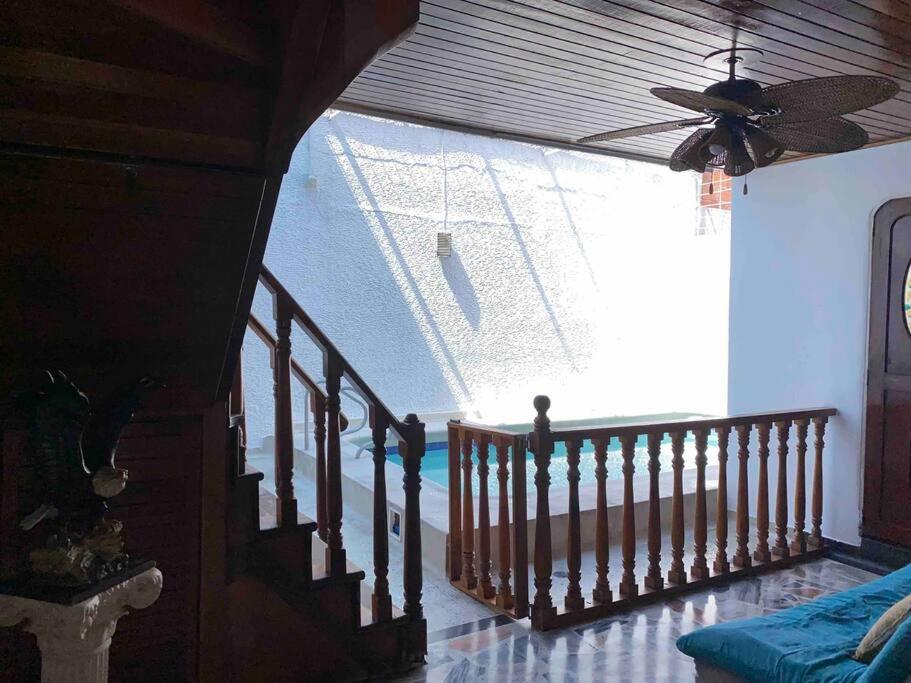 Lujosa casa, excelente sector, amplia con piscina في كوكوتا: غرفة بها درج مع نافذة كبيرة
