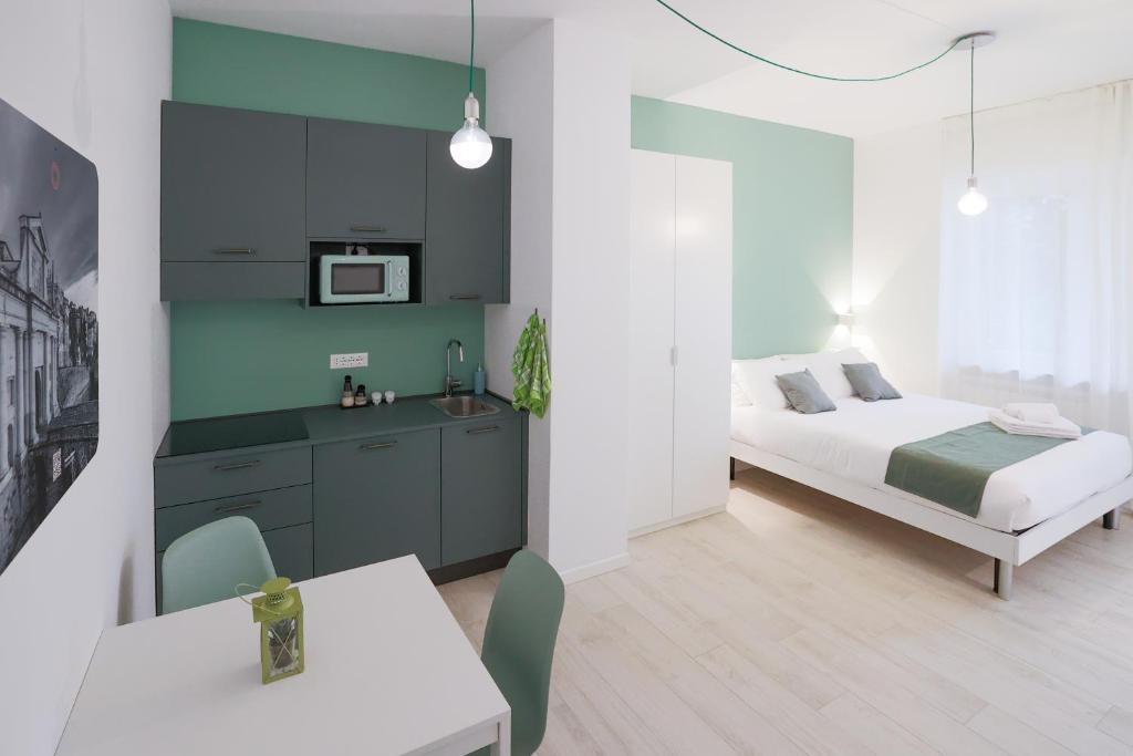 een slaapkamer met een bed en een tafel en een keuken bij Cà Cianfer in Bergamo