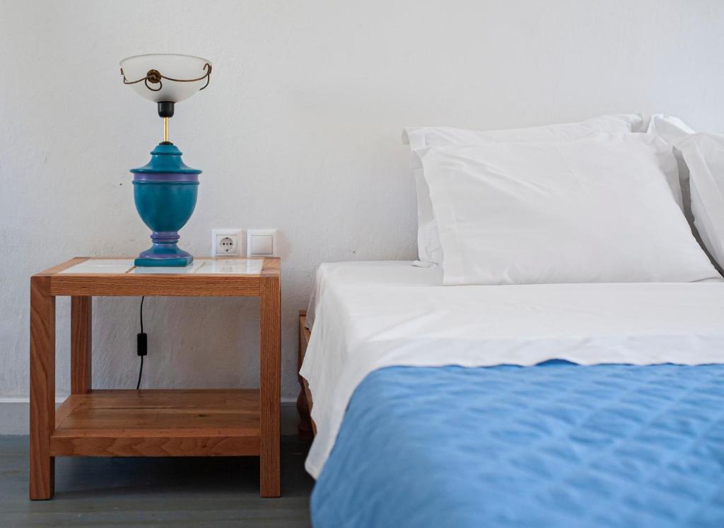 a blue lamp on a night stand next to a bed at Militiko in Himare