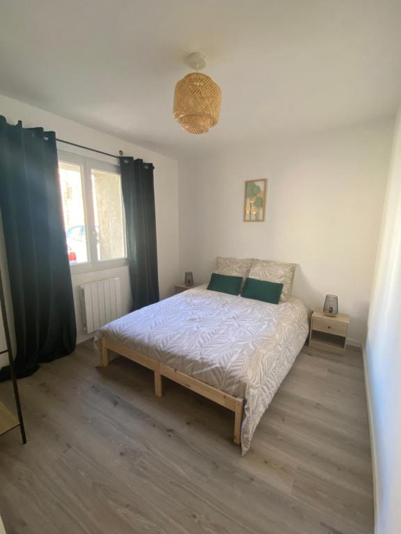 Schlafzimmer mit einem Bett und einem Fenster in der Unterkunft Appartement proche CNPE et PIPA in Saint-Denis-en-Bugey