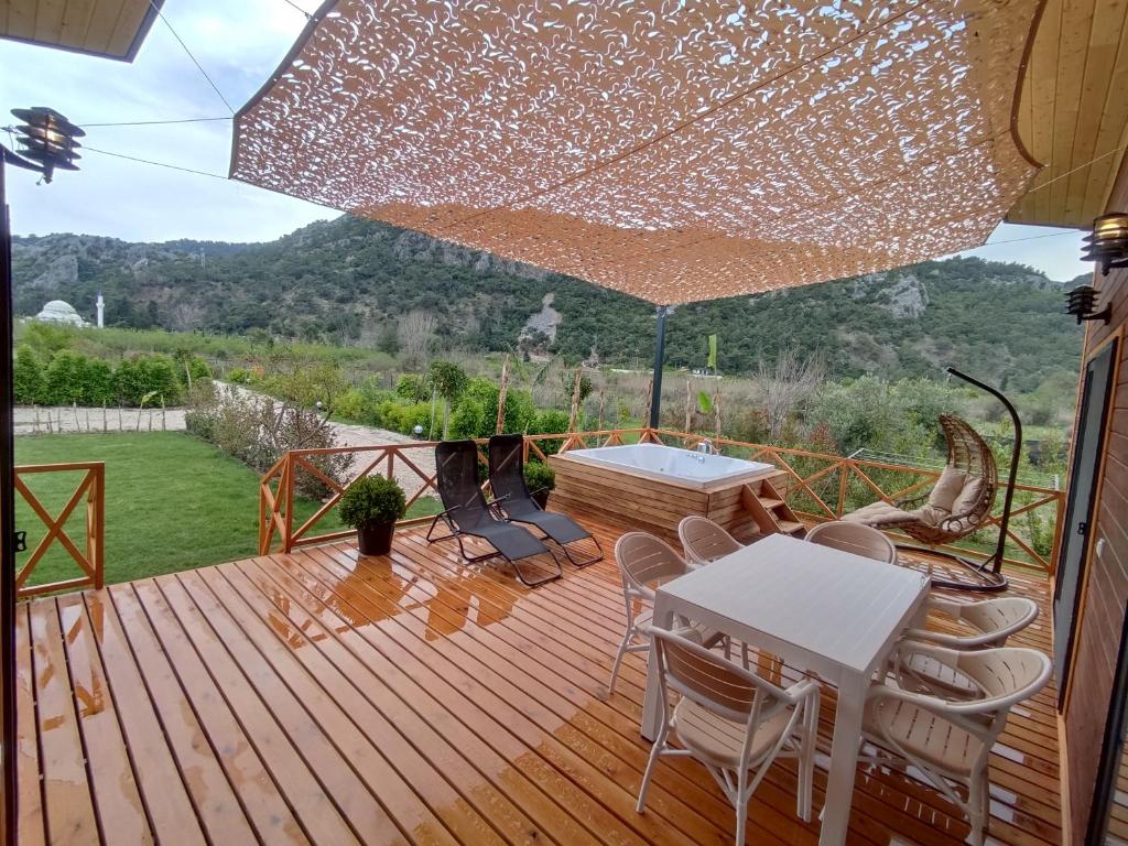 eine Terrasse mit einem Tisch, Stühlen und einem Sonnenschirm in der Unterkunft Villa Nar in Cıralı