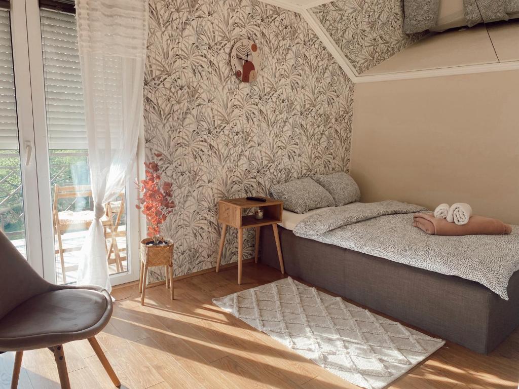 een slaapkamer met een bed, een tafel en een stoel bij Cozy House in Lazarevac