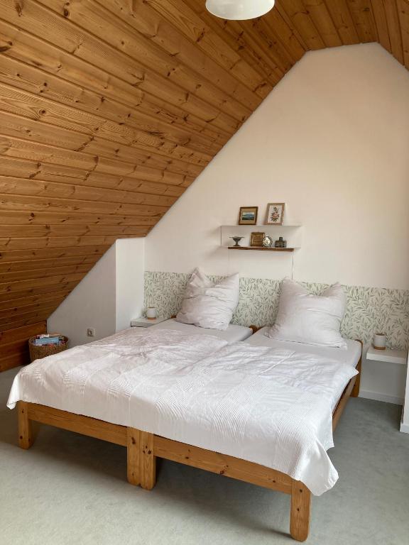 1 dormitorio con 1 cama grande y techo de madera en Ferienwohnung Frangenberg, en Lindlar