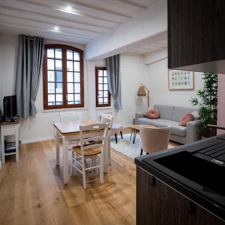 une cuisine et un salon avec une table et des chaises dans l'établissement Tendr’Escale, honfleur, à Honfleur