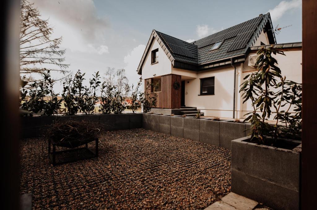 a house with a fence and a chair in front of it at Coś miłego in Gowidlino