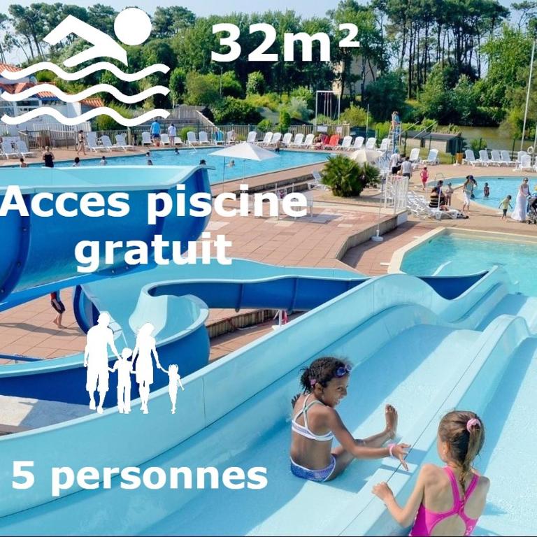 un parc aquatique avec 2 enfants sur un toboggan dans l'établissement Appartement T2 Residence Le Club, à Talmont-Saint-Hilaire