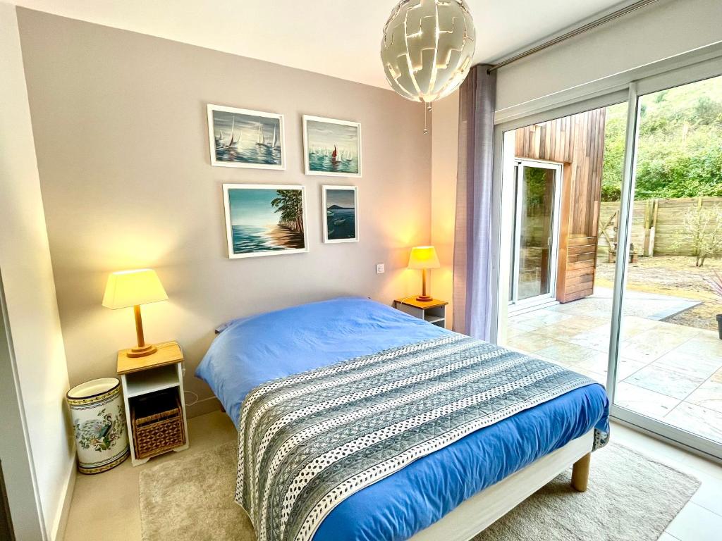 um quarto com uma cama e uma grande janela em Les Néreides em Saint-Laurent-sur-Mer