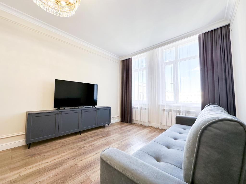 a living room with a couch and a flat screen tv at Рядом с Экспо Большая 2х комнатная 70м2 и 1-комнатная 45м2 рядом с Экспо in Astana