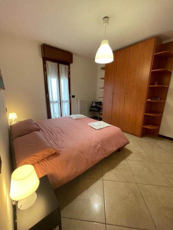 sypialnia z dużym łóżkiem i drewnianą szafką w obiekcie Casa Linabelli w mieście Reggio nell'Emilia