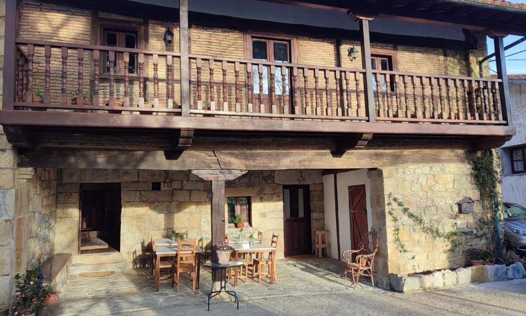 Castillo-PedrosoにあるPosada La Daliaのバルコニー、テーブル、椅子が備わる家