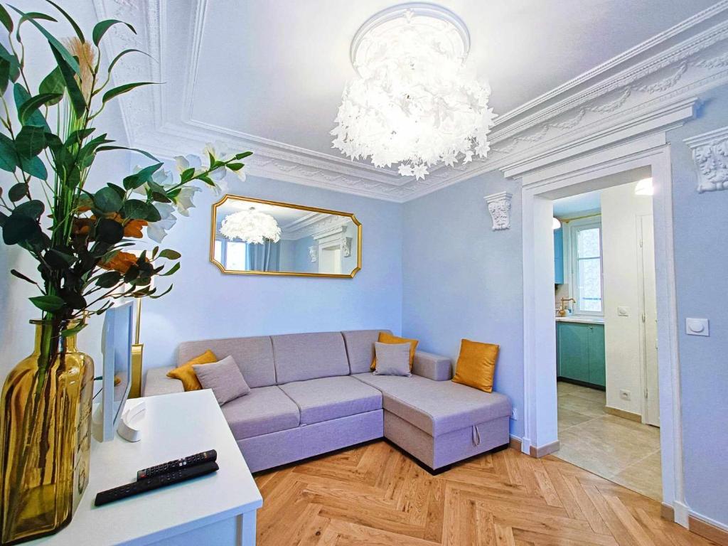 sala de estar con sofá púrpura y espejo en Au Petit Trianon Bleu, en Versalles