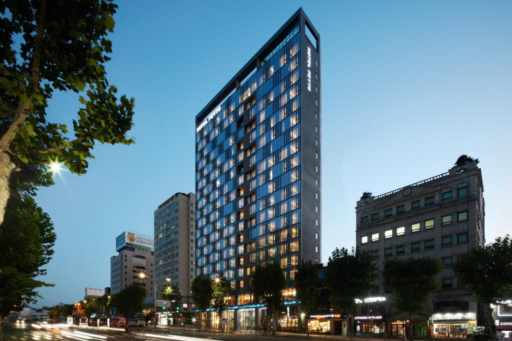 a tall building on a city street at night at Hotel Peyto Gangnam in Seoul