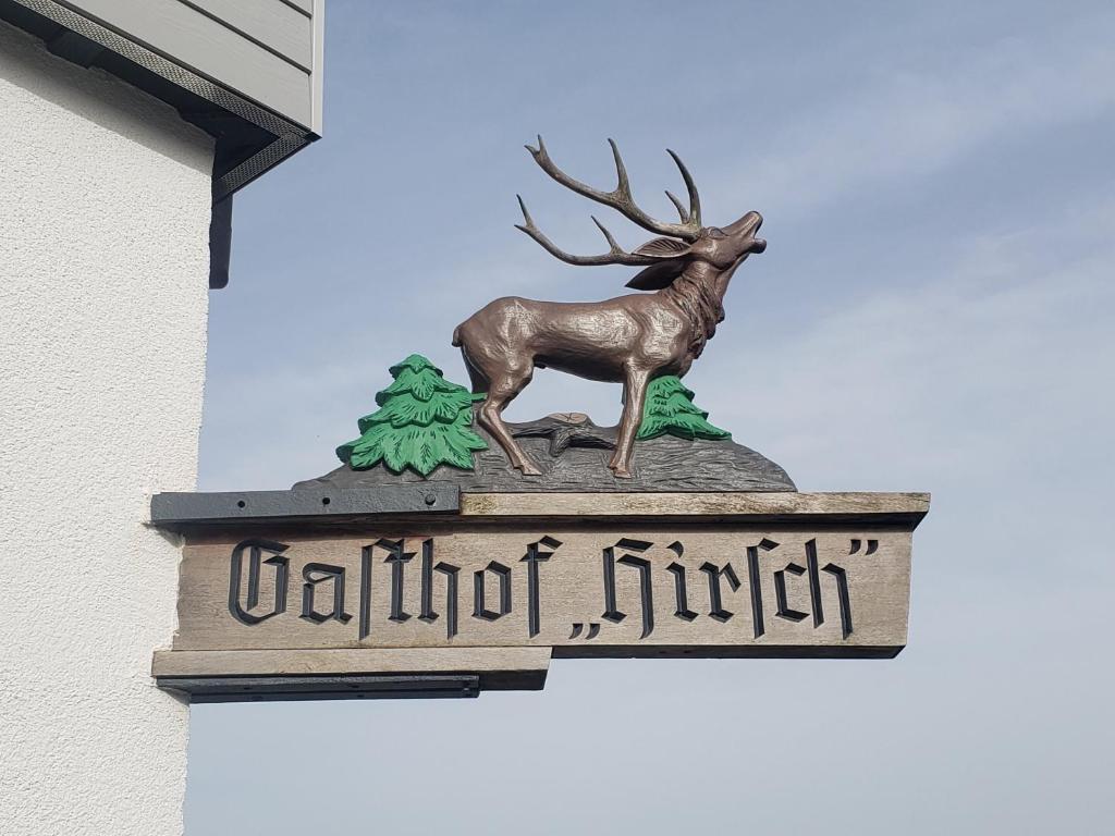 una estatua de un ciervo en un cartel en un edificio en Alter Hirsch, en Pfalzgrafenweiler
