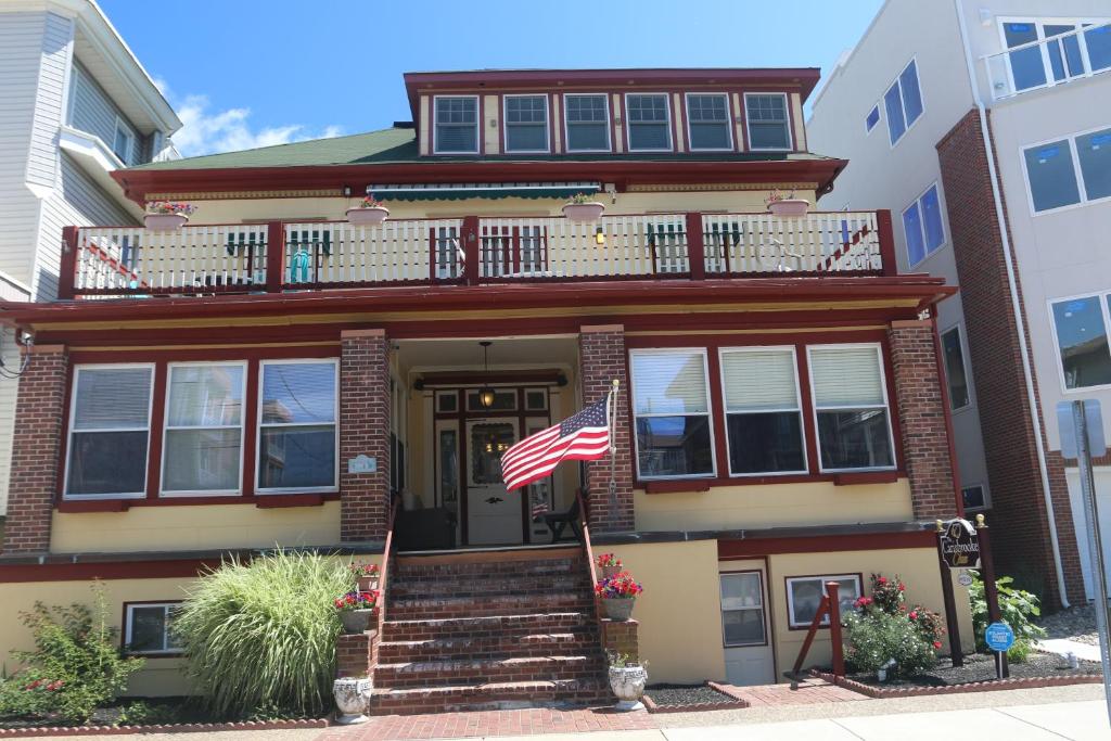 a house with an american flag in front of it at Carisbrooke Inn Bed & Breakfast in Ventnor City