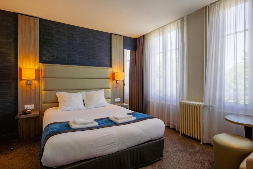 Hotel de la Gare Troyes Centre في تروي: غرفة فندق عليها سرير وفوط