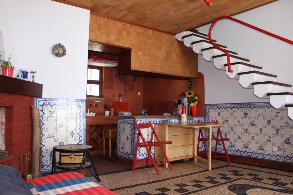 a kitchen with a counter and a table in a room at Refúgio da Vila Santiago in Sesimbra