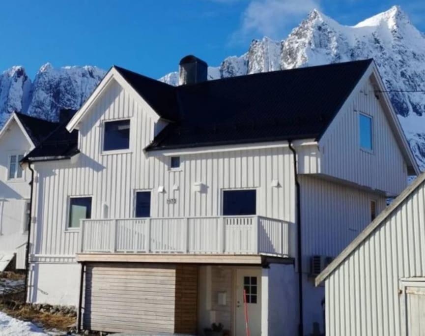 una casa blanca con una montaña en el fondo en Norwegian house Maria Stua, en Mefjordvær
