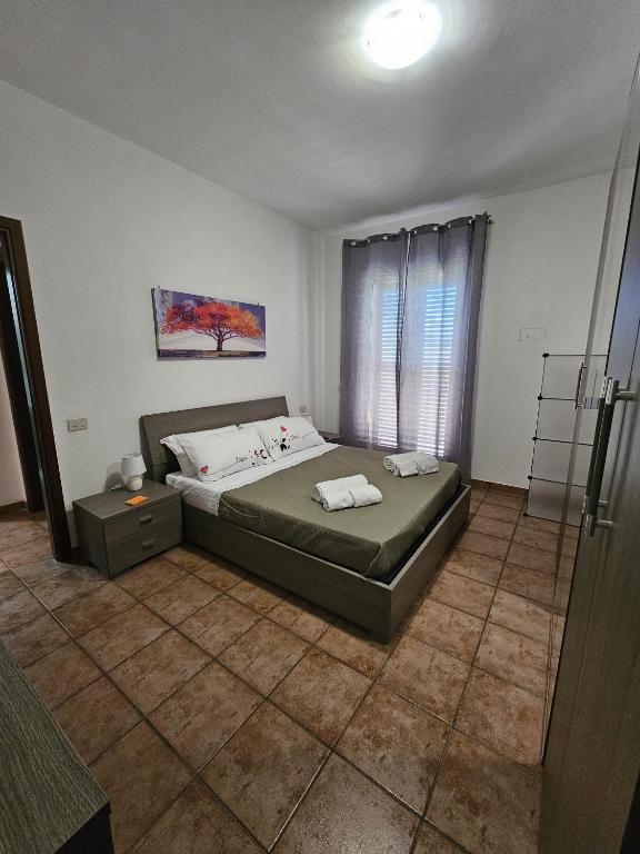 a bedroom with a bed with two towels on it at Nika Holiday Home in Casteldaccia