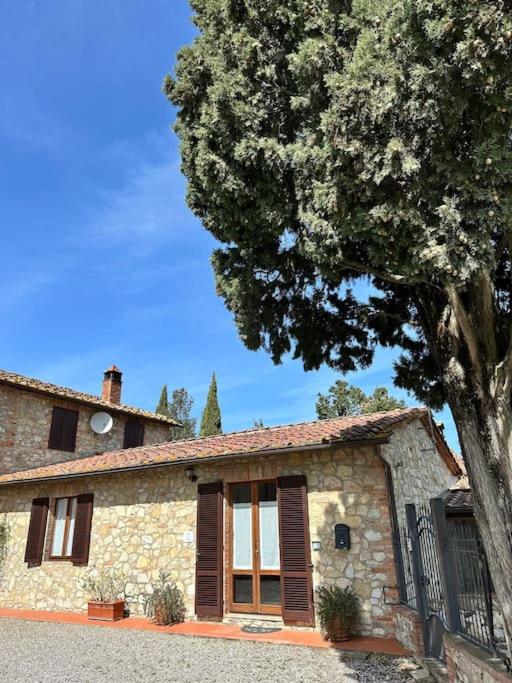 a stone house with a tree in front of it at Casa il Cipresso in Castelnuovo Berardenga