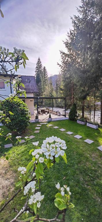 a garden with white flowers in the grass at Riverside Guesthouse in Ig