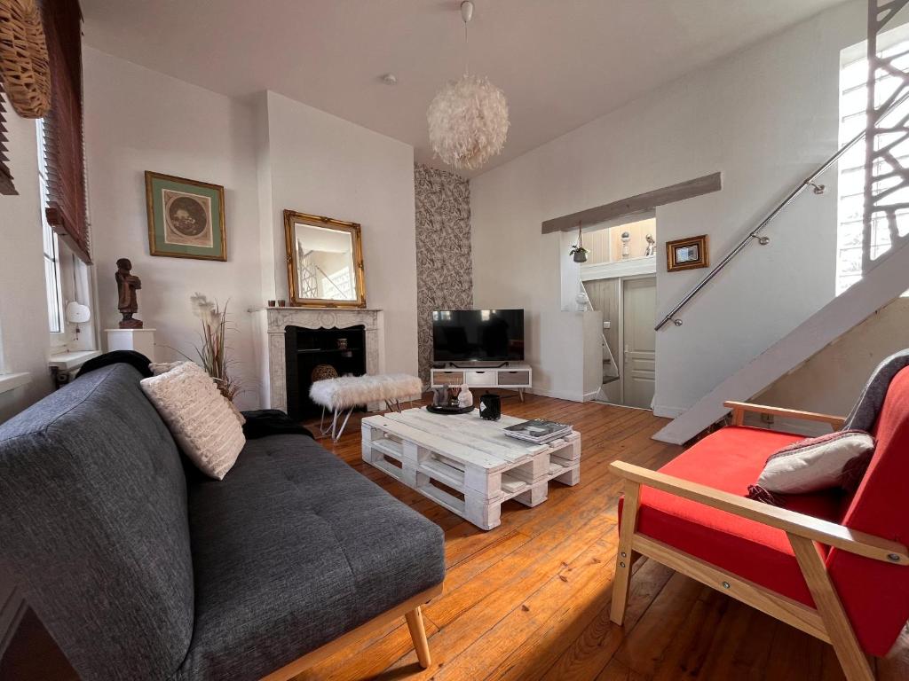 a living room with a couch and a table at Le Refuge d'Omer in Saint-Omer