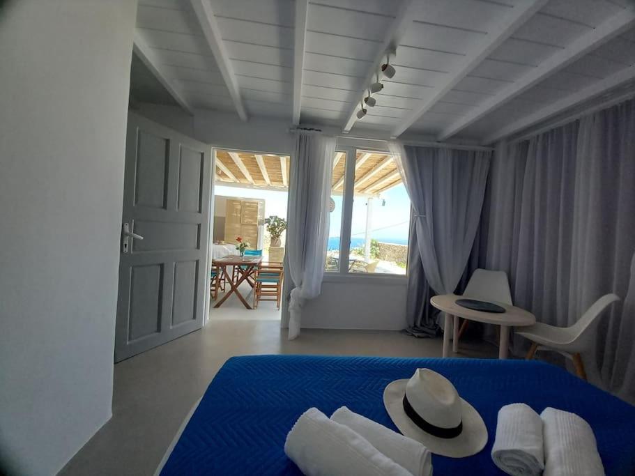 a bedroom with a blue bed and a view of the ocean at Blue Waves Suite Mykonos in Kalafatis