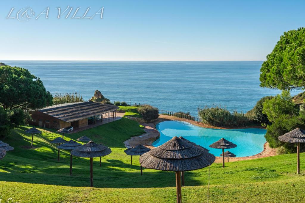 uma vista aérea de um resort com uma piscina e guarda-sóis em ALVOR VILLAGE BY THE SEA em Alvor