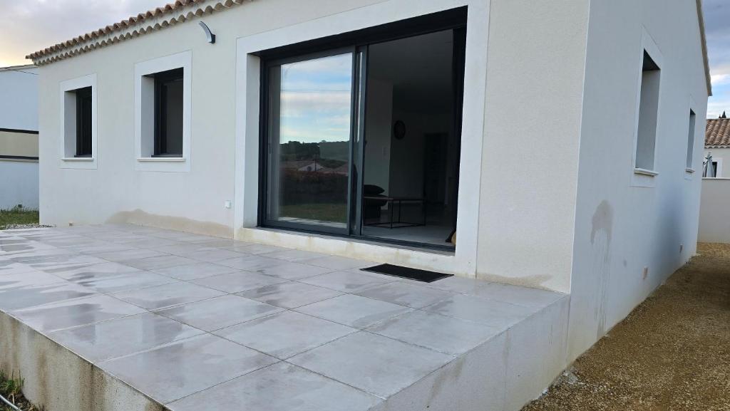 a white house with a large window and a patio at Maison des peupliers in Piolenc