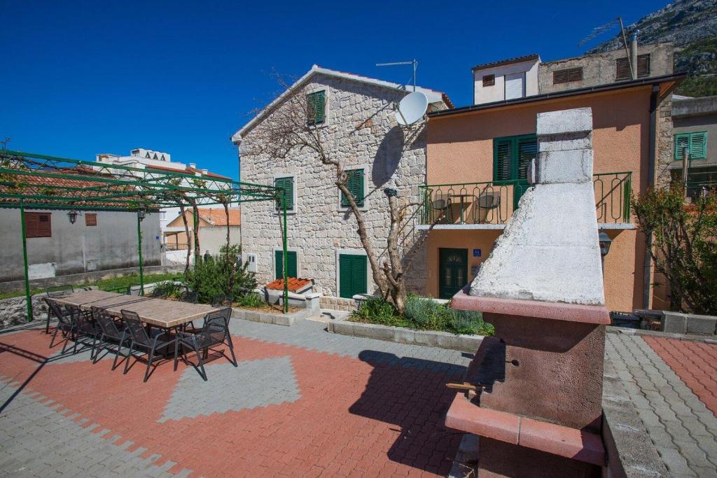 a patio with a table and chairs and a building at TerraMar Apartments in Baška Voda