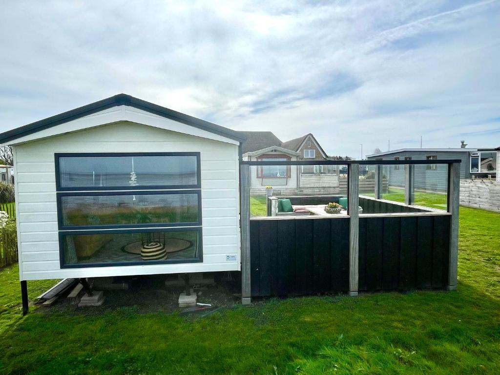 a small house with a window and a garden at Chalet direct aan Waddenzee in Westerland