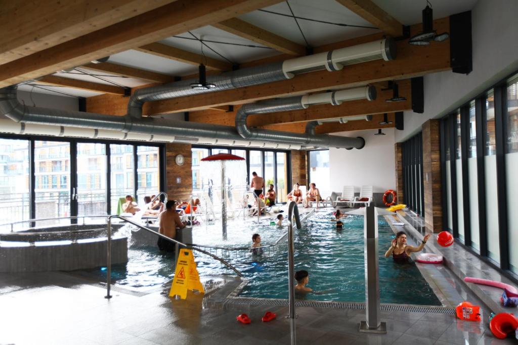 a group of people in a swimming pool at Sunny Haven Bel Mare Parking, Basen FREE in Międzyzdroje