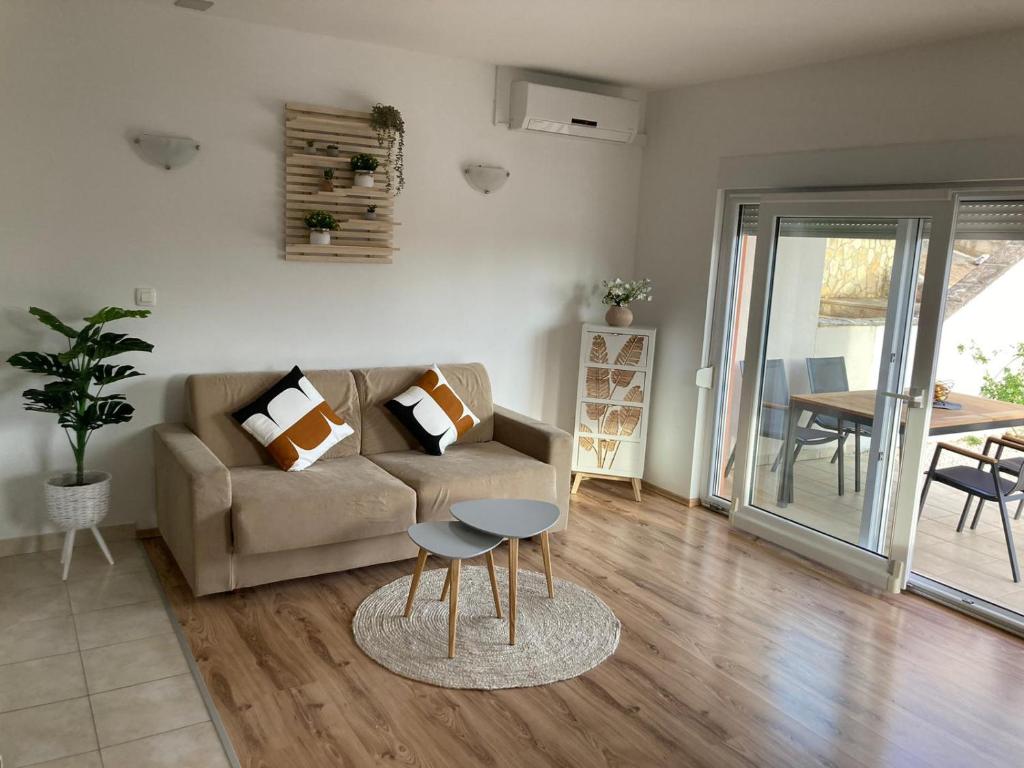 uma sala de estar com um sofá e uma mesa em Apartments Dante Domus Aurea em Milna