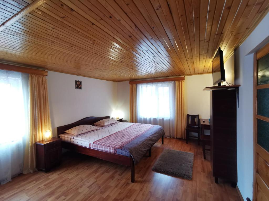 Un dormitorio con una cama y un techo de madera. en Nona Highland Home, en Moieciu de Jos