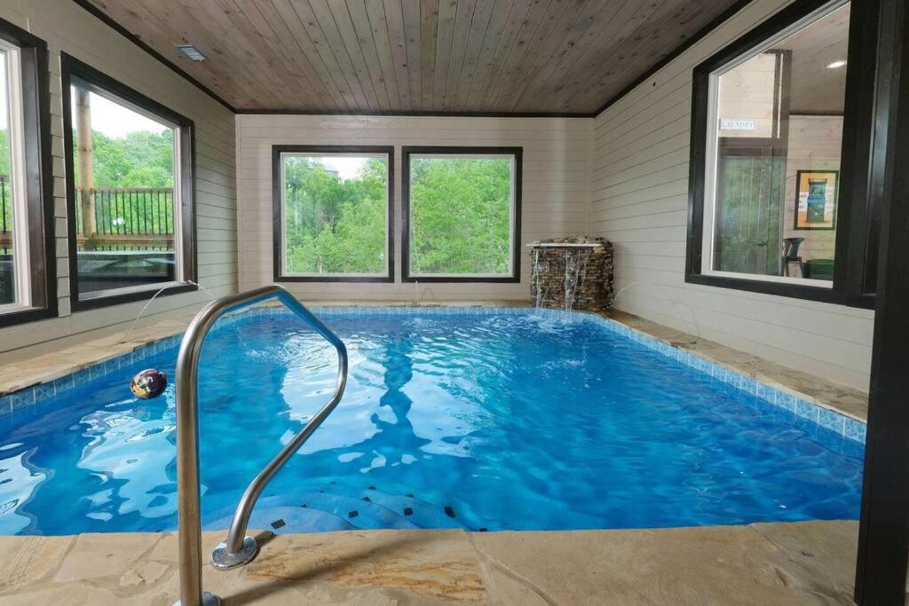 a large swimming pool in a house with windows at Majestic Pines Lodge in Sevierville
