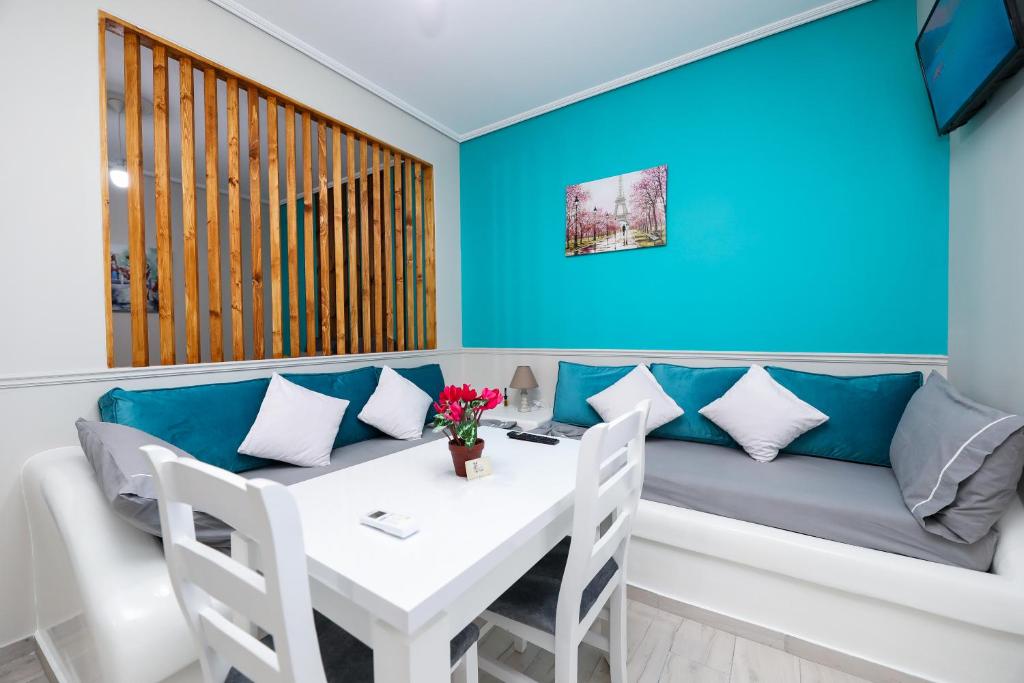 a dining room with a table and a blue wall at Guest House Narta in Vlorë